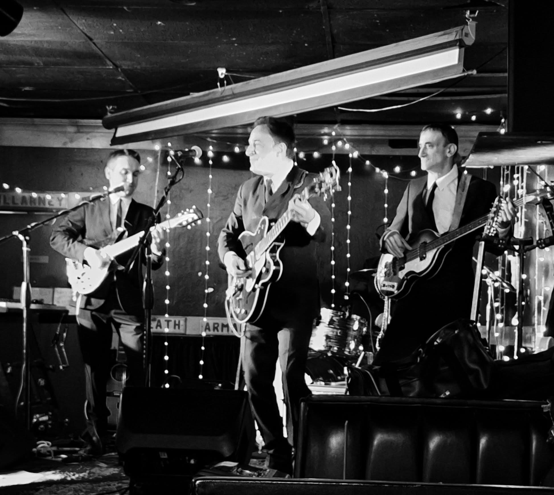 Boots & Suits on stage in suits under stage lights